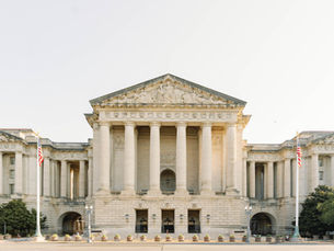 Exterior front face of the Andrew W. Mellon Auditorium when viewed from across the street on a sunny morning.