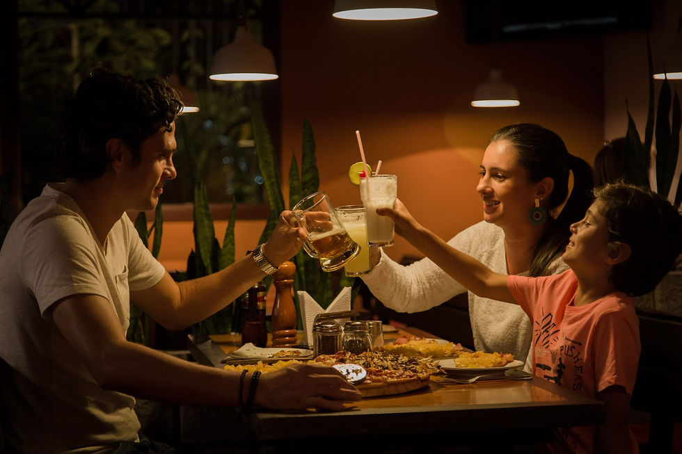A photograph of a family saying cheers with their drinks over dinner
