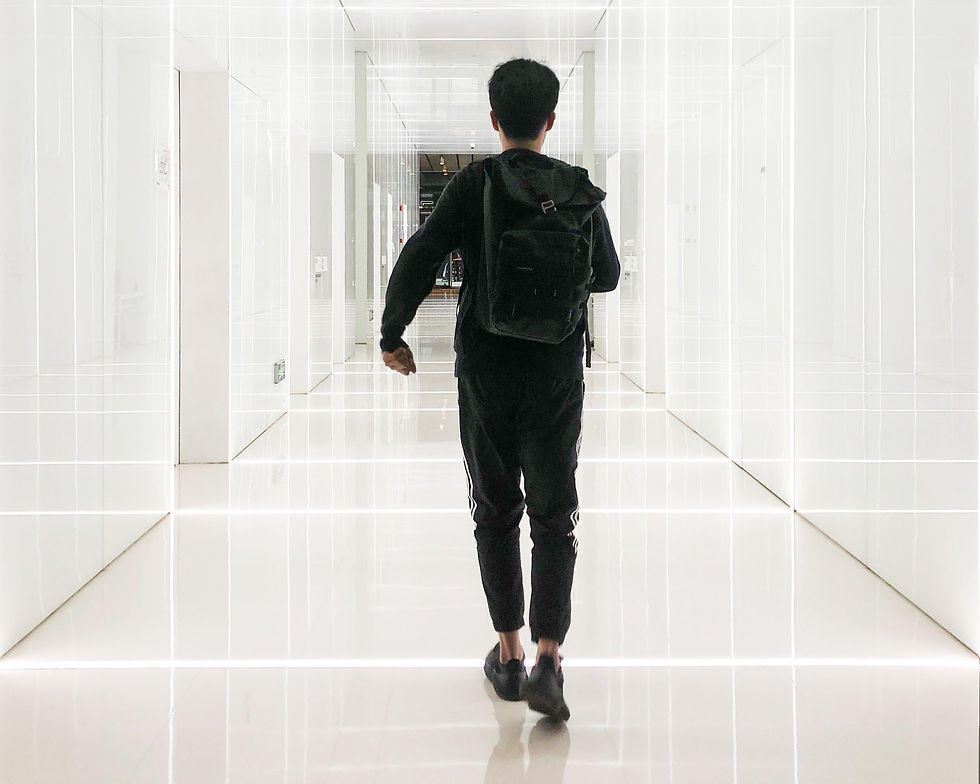 A photograph of a boy walking along a white corridor