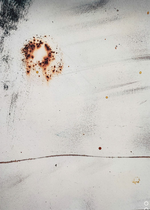 Surface blanche marquée par une trace circulaire de rouille – photographie d’Hélène Bernard.