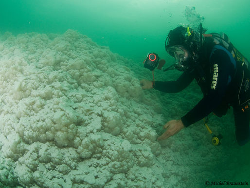 Diver close to a huge salted rock underwater the Dead Sea