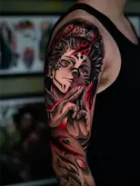 Brazo con tatuaje de anime, detalles rojos y negros en diseño.