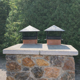 Stone chimney repair in Claremont with new concrete crown and dual chimney caps installed by SMC Masonry