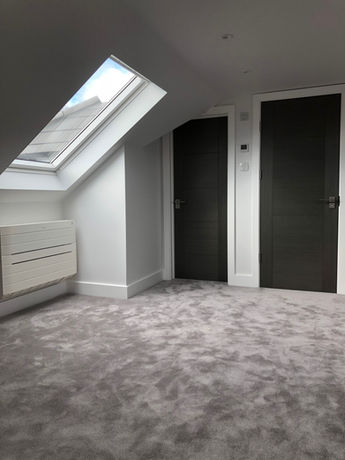 Interior room view with skylight and two dark doors. MSQ Design.