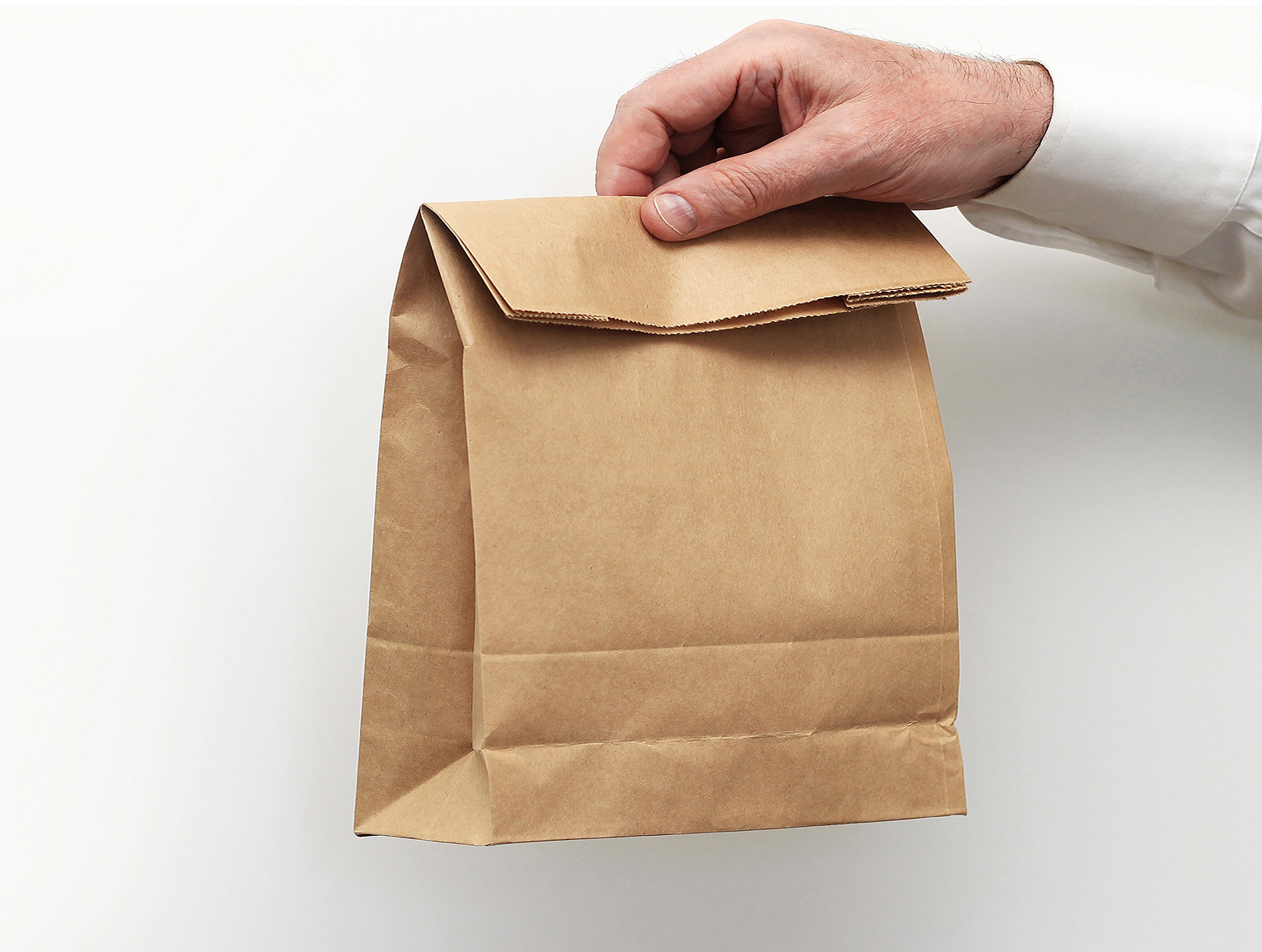 close-up-male-holds-hand-clear-empty-blank-craft-paper-bag-takeaway 2.png
