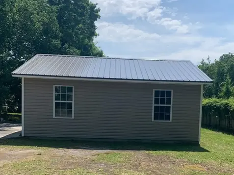 One-story brick home with a new metal roof installed by roofing contractors — an alternative to traditional roof shingle companies.