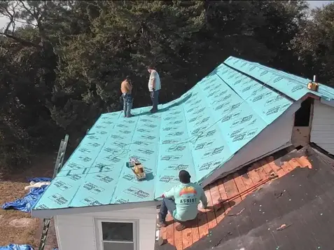 Roofer working on roof underlayment installation as part of a fortified roof certification project by a licensed roofing company.