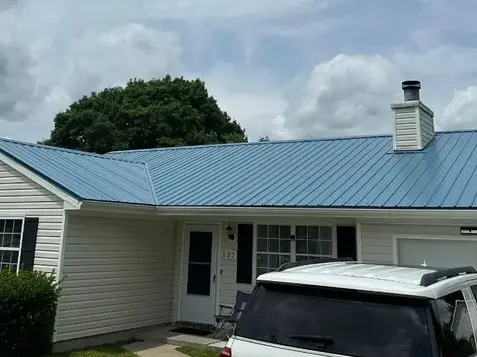 Roofer applying underlayment to a metal roof, part of the fortified roof certification process for weatherproofing and safety.
