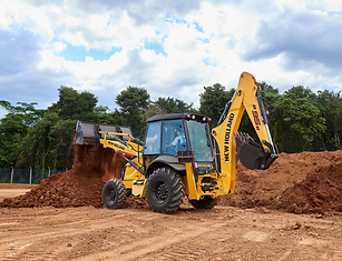 Retroescavadeira amarela modelo B95b trabalhando com terra em projeto de obra.
