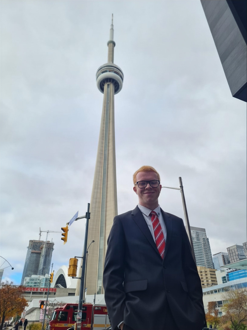 Sam Carruthers stood in front of the CN Tower in Toronto