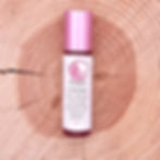 GMG's Happy Citrine Roll-On Bottle on a wood background