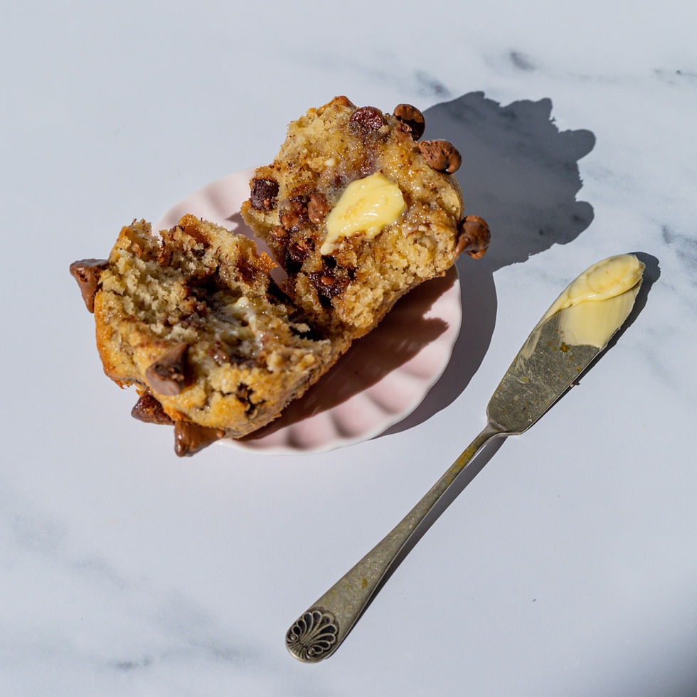 Banana chocolate chip muffin cut in half smothered in melting butter