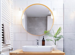 Bathroom with a large round mirror.