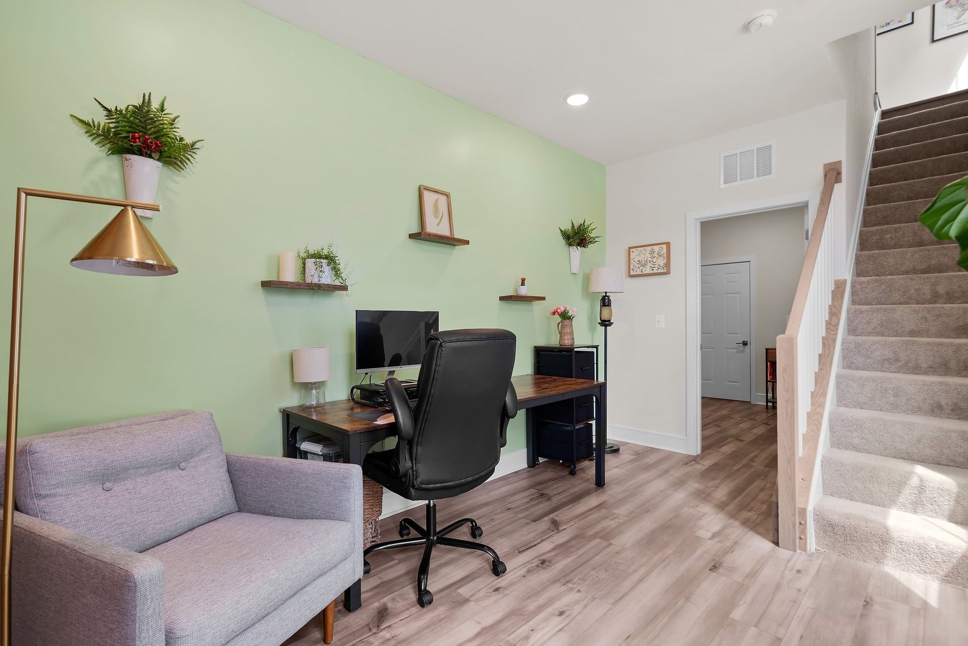 Home entryway with LVP flooring and a stair case