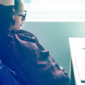 Woman by window with laptop on Gorett Reis career and life coach website.