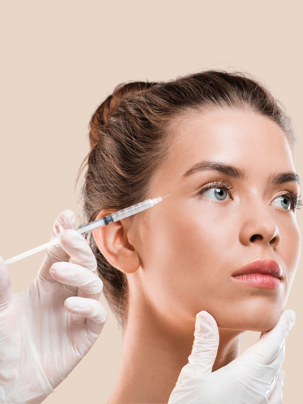 Medical professional injecting aesthetic treatment near the eye of a woman Bótox tercio superior.