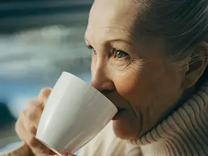 Woman drinking a cup of Triphala for digestion.