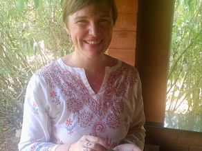 Belinda sitting on a bench at Vaidyagrama in 2016, eating traditional Ayurvedic prasad food served on a banana leaf after completing Panchakarma treatment.