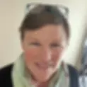 Close-up portrait of Ayurvedic Practitioner Belinda Baer smiling warmly while wearing a soft scarf.