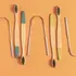 Colorful background with wooden tooth brushes and stainless steel tongue scrapers for oral health Ayurveda.