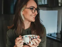 A woman drinking warm water as a daily Ayurvedic routine for women over 40.