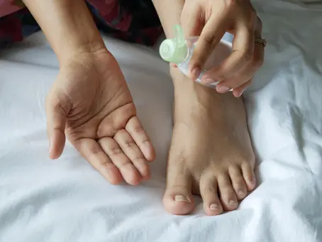 Hands apply oil to a foot on a white bed as part of your Ayurvedic Sunday reset.
