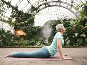 A woman doing the cobra pose as part of Kapha balancing yoga to reduce heaviness and fatigue.