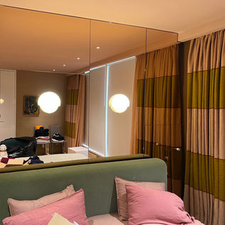 Lighting above a bed on a mirrored wall