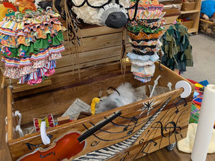 Wooden box, open with instruments on inside and decorated with musical notes and instruments on outside