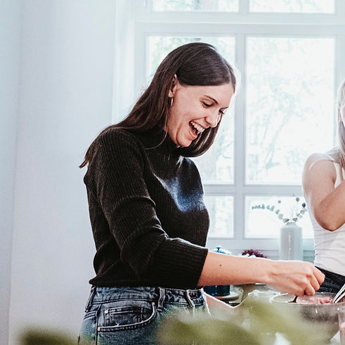 Ernährungsberatung, Alina Walter, steht in der Küche beim Kochen und hat große Freude und Spaß dabei