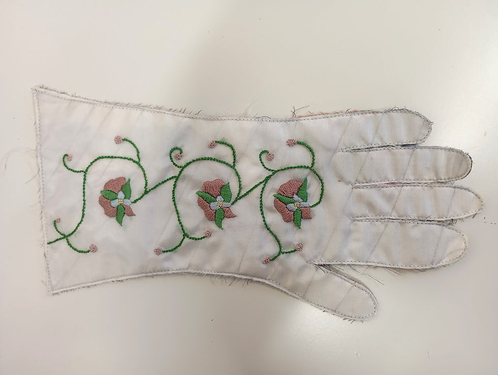 Thumbnail: white fabric cut out from a glove pattern with hand embroidered pink flowers worked in silk thread
