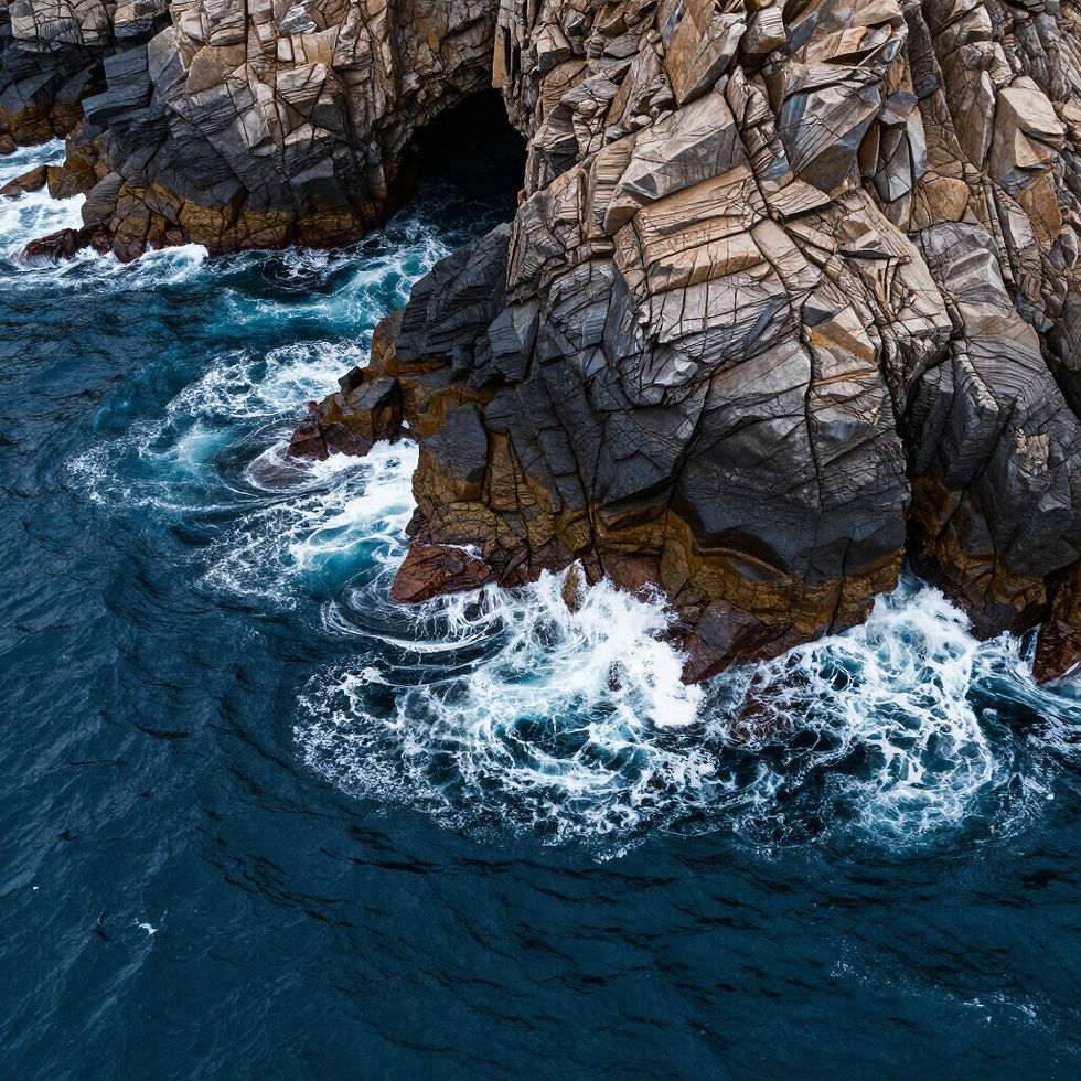 Waves crashing against rocky cliffs and ocean cave