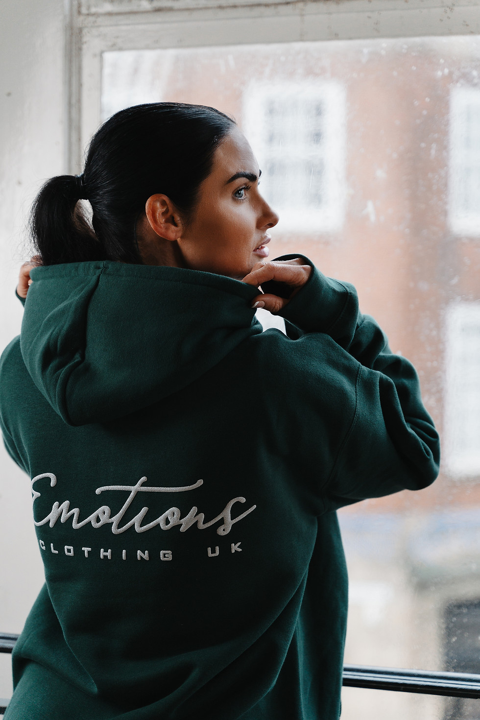 Close-up of bottle green hoodie fabric highlighting soft cotton blend texture and stitching