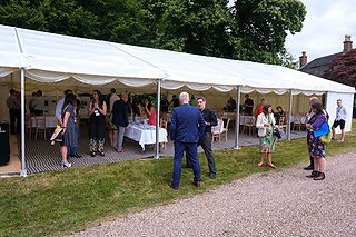 attendees of sustainable corporate event standing by marquee on country estate
