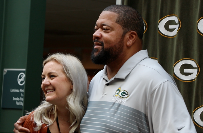 A seminar attendee posing for a picture with a retired Green Bay Packers player.