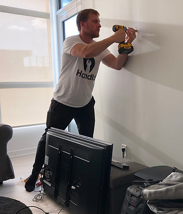 HANDLD HANDLR technician preparing a wall for TV mounting in a Toronto condo
