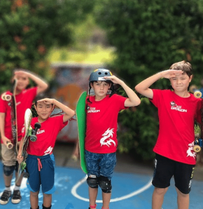 A Skate Dragon gets involved in the Dragons pledge during the urban adventure camp. Skate Dragons group class, smiling and enjoying their skateboarding lessons - in Singapore