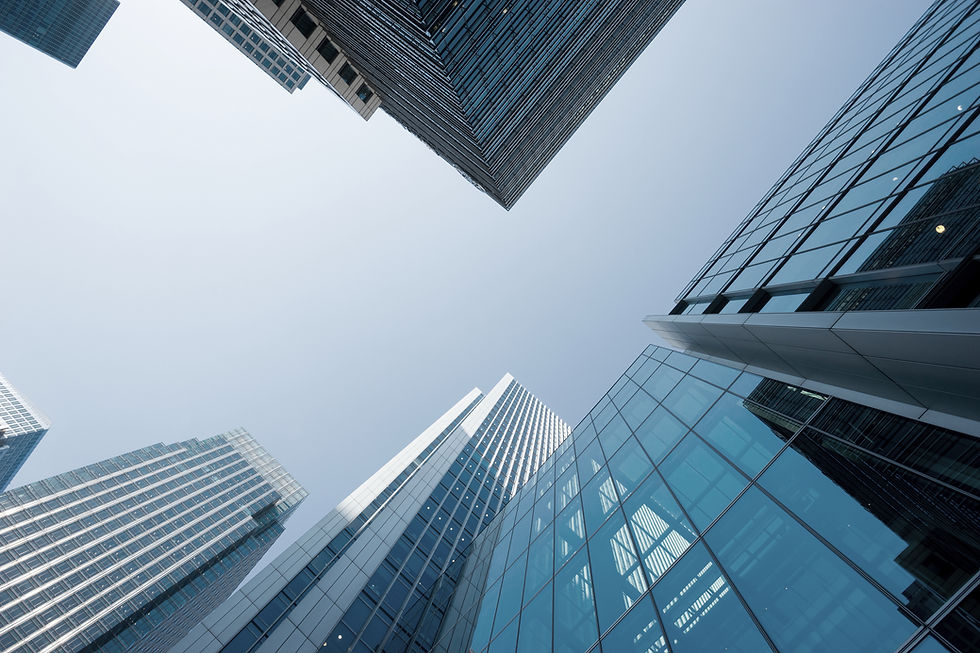 Moderne Büro- und Investmentimmobilien aus Glas und Stahl im urbanen Hochhausensemble bei klarem Himmel, Froschperspektive