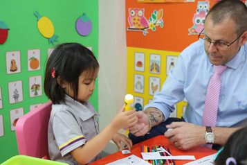 Young student at British Learning Centre engaged in a craft activity with tutor