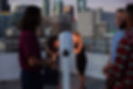 Friends enjoying a Drop Off Photo Booth on a city rooftop at dusk
