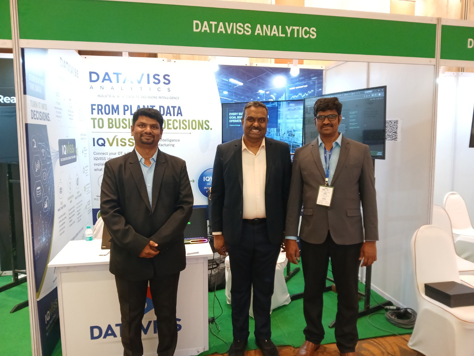 Three attendees standing together at the Dataviss Analytics exhibition stall during the CII Tamil Nadu Sustainable Manufacturing Summit.