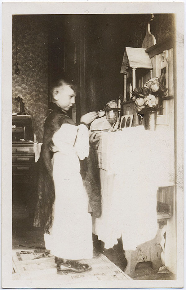 ALTAR BOY PRAYS at SMALL HOME ALTAR