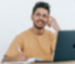 an autistic adult smiling in front of his laptop while planning his routine