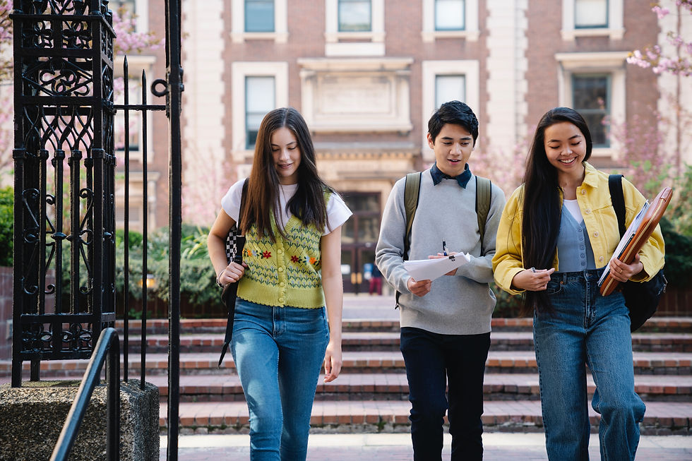three neurodivergent students talking as they descend stairs on a campus