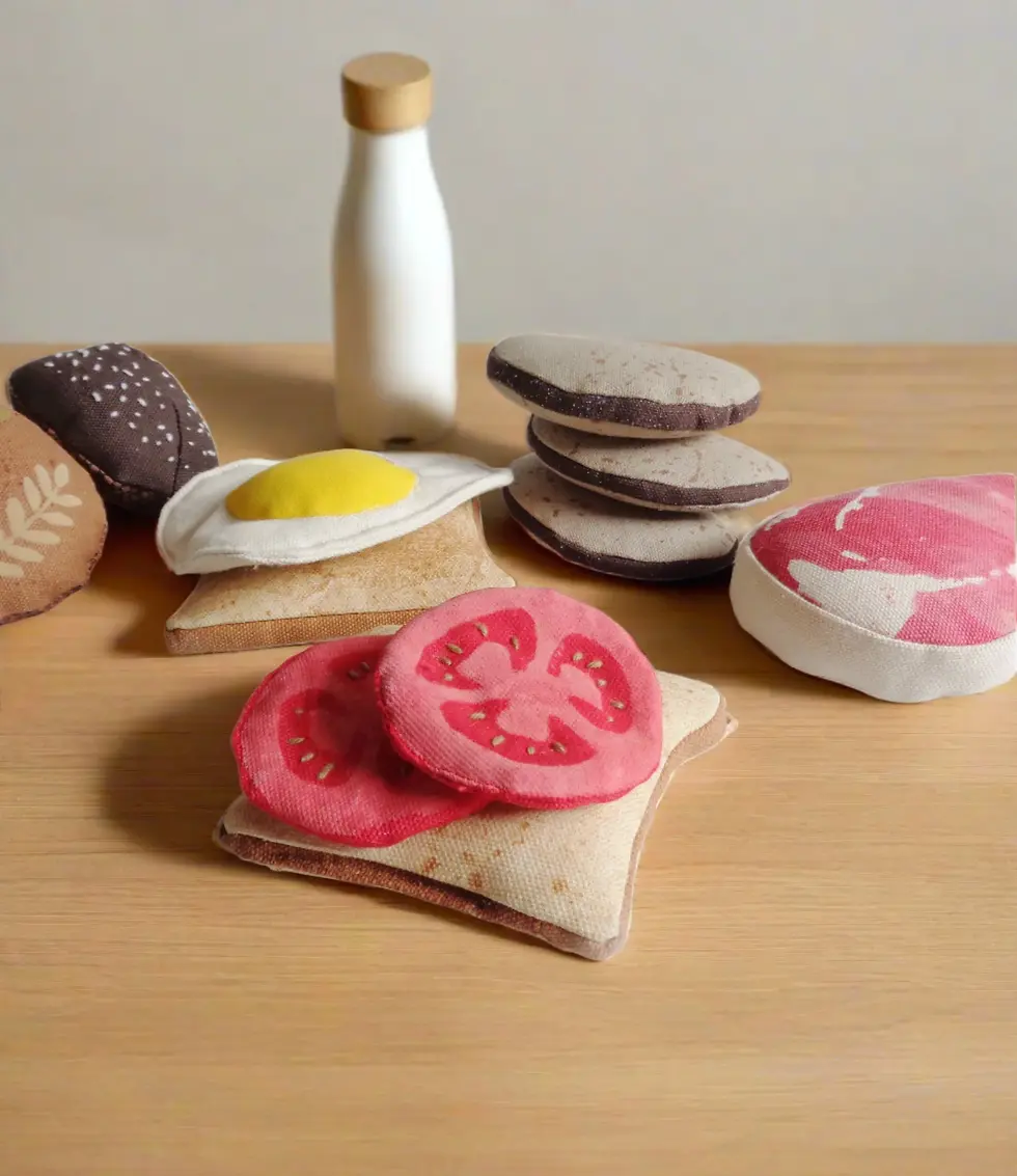 A table set with different pretend play foods including and egg and tomato