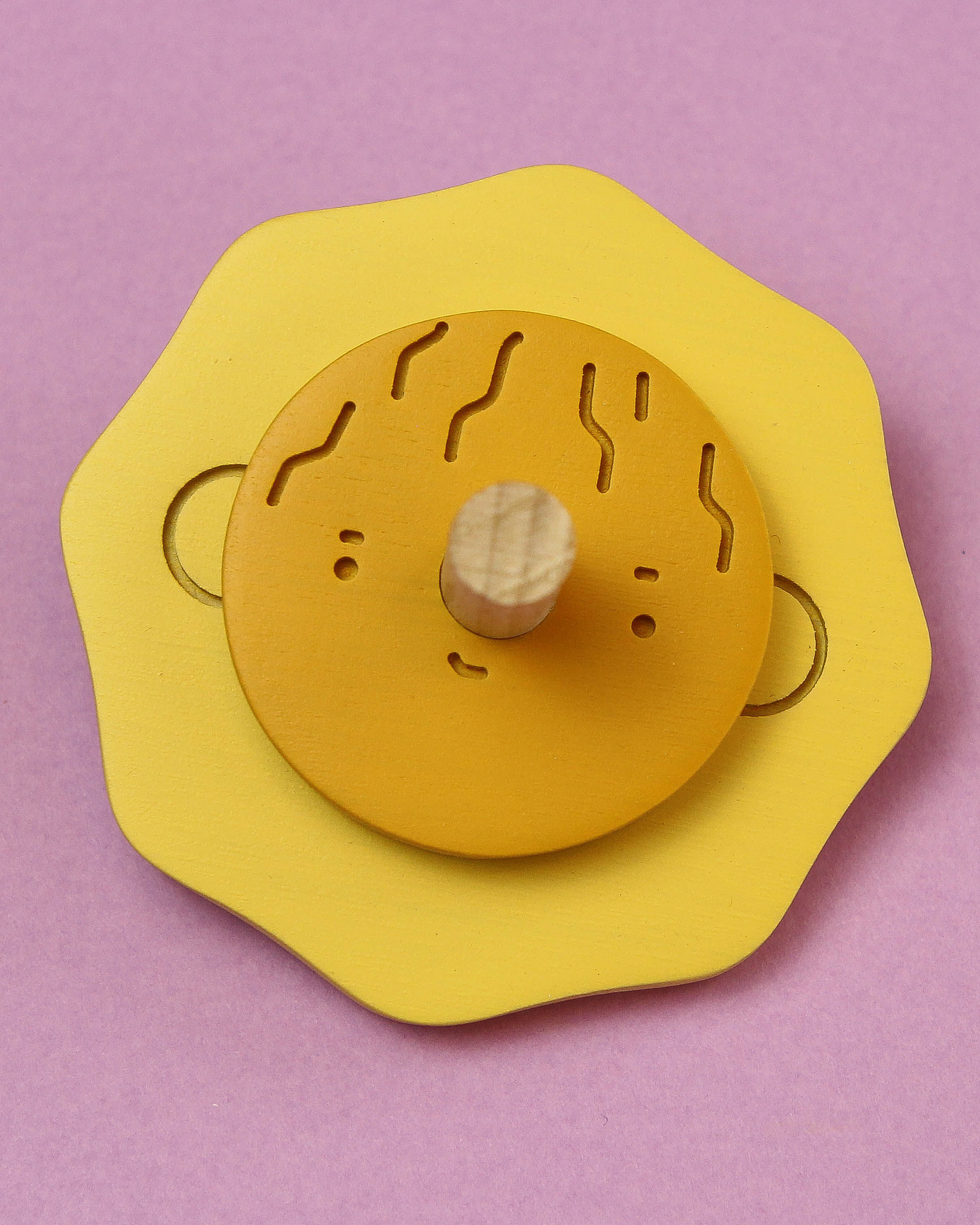Wooden spinning top with cute face.