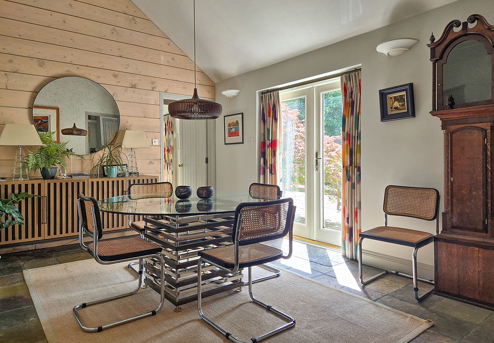 Dining Room with a feature wall of Spruce Roughboard wall panelling. Mid-Century Cesca Knoll Dining chairs. Bluebell Gray Curtains