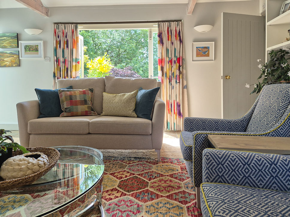 Colourful interior design scheme with bold geometric armchairs, kilim rug and watercolour print curtains from Bluebell Gray