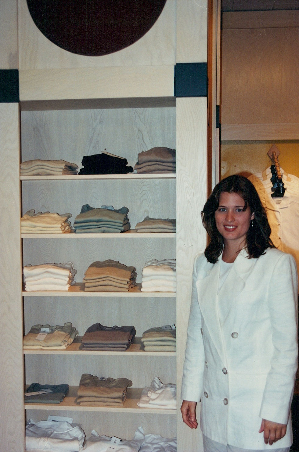 Sales consultant Jennifer showing a shelving unit of knitwear.