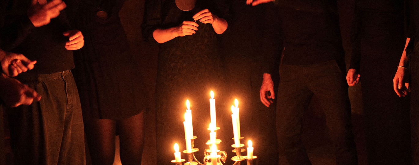 Vokalgruppen NOOR synger a cappella folkesang i levende lys under koncert i kirkerum – ledet af Nini Julia Bang.